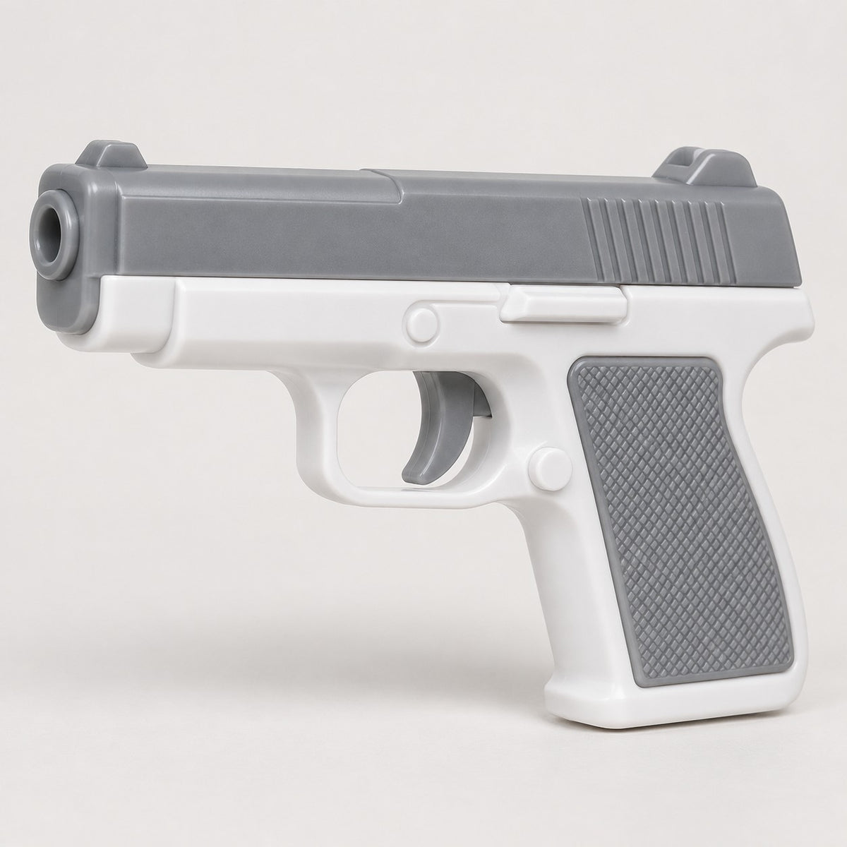 The gray and white water pistol is centered on a soft gray studio background with a light shadow.