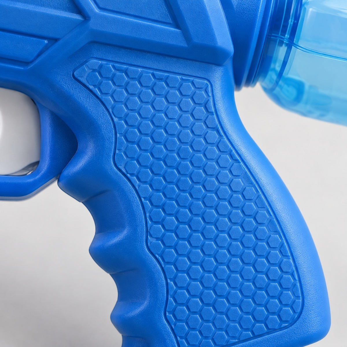 Close-up of the water squirt gun's molded blue grip texture and clear reservoir edge.