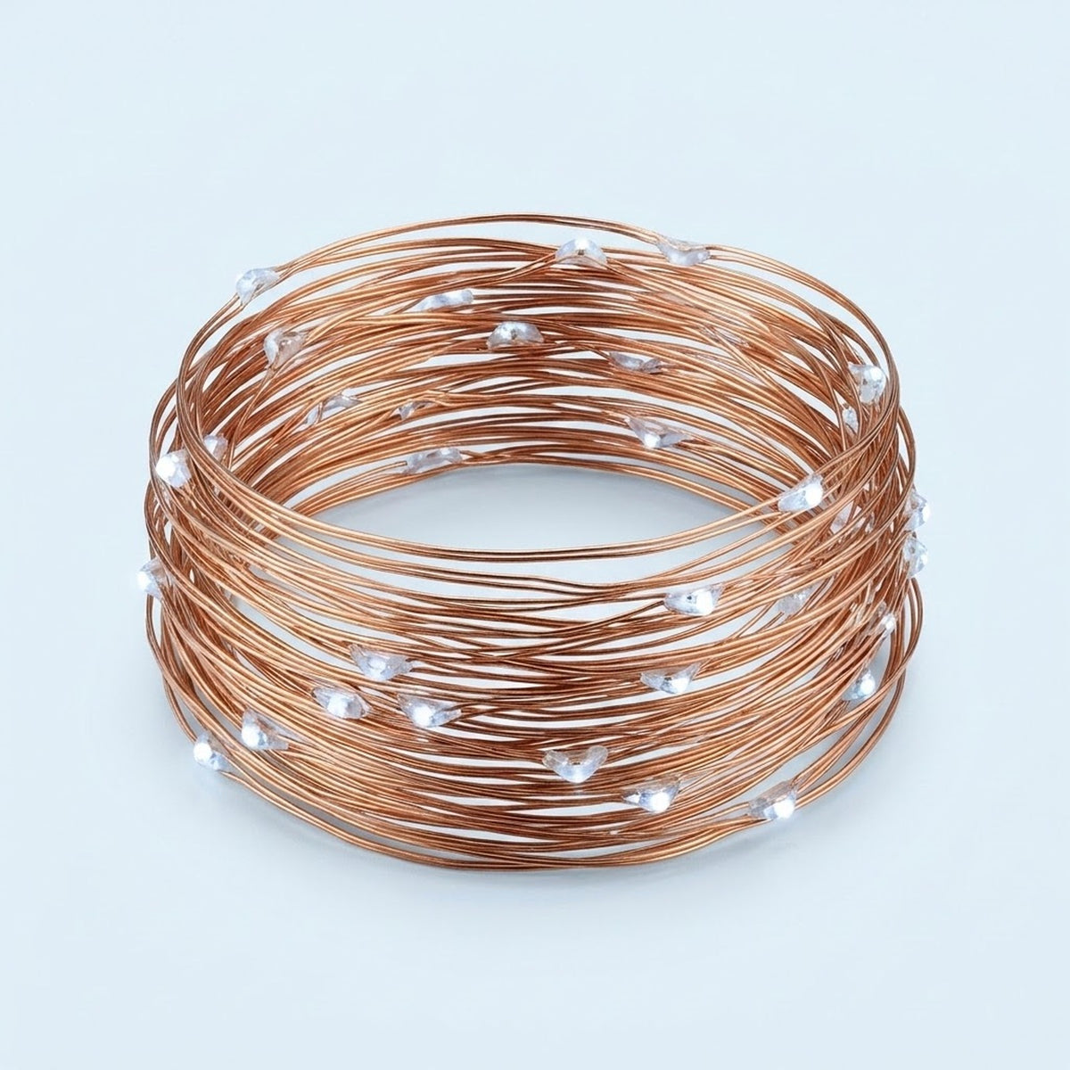 Copper-colored wire string light coiled into a circle with small cool white LEDs against a pale blue background.