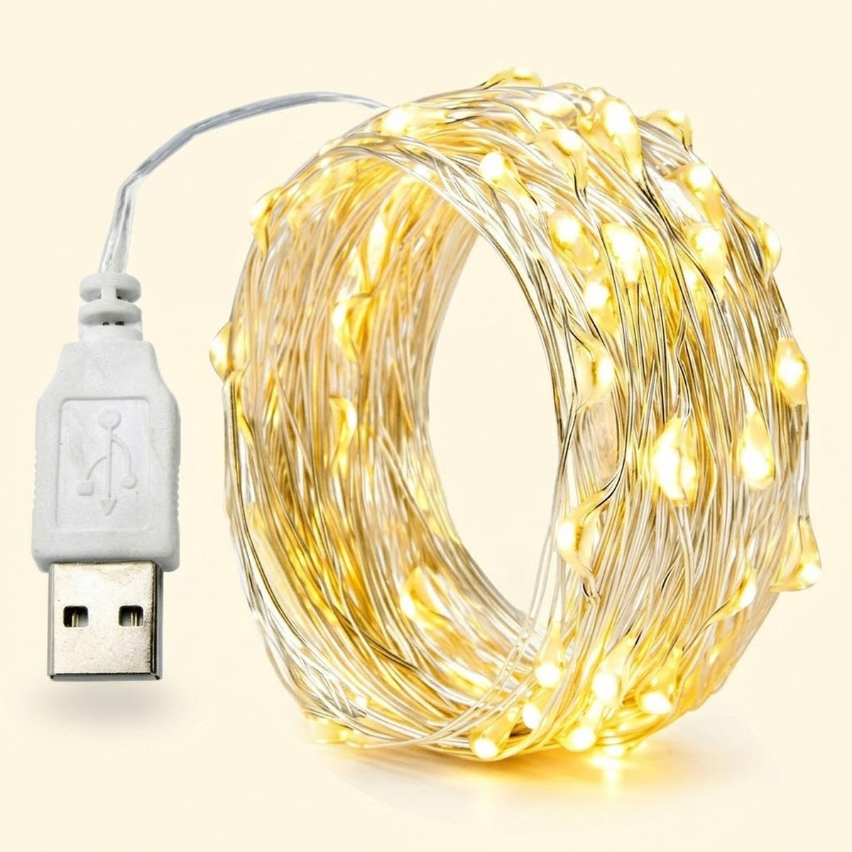 Coiled USB fairy string lights with warm white glowing bulbs on thin wire, shown with a white USB connector cable on a light cream background.