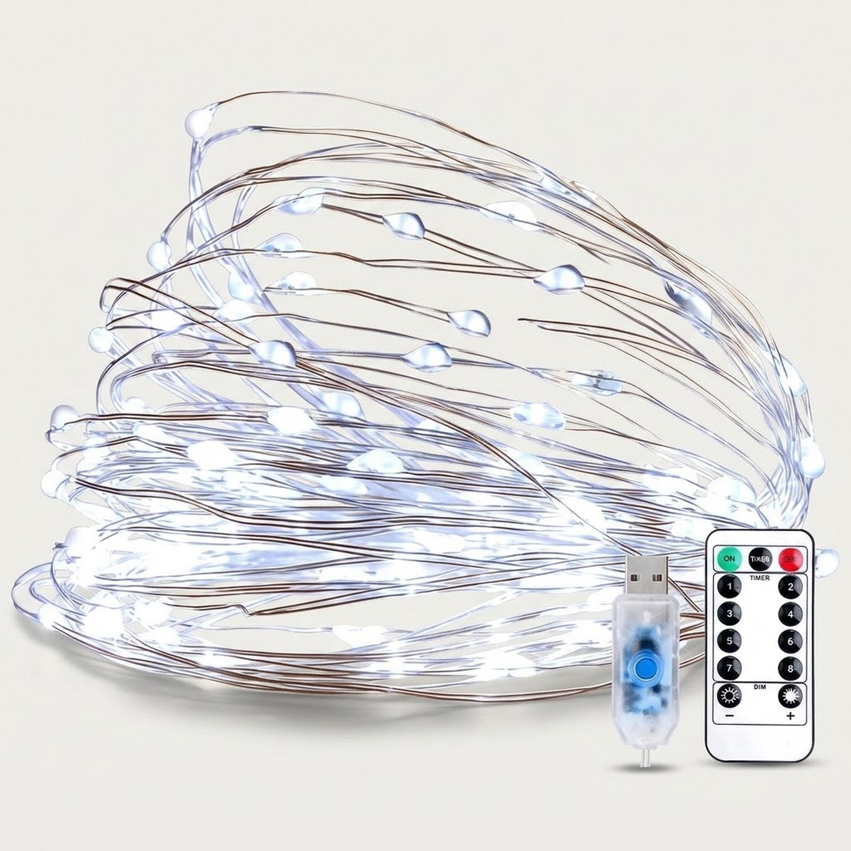 White LED fairy string lights with thin copper-colored wires, shown coiled with a USB charging cable, a small blue decorative piece, and a white remote control on a light beige background.