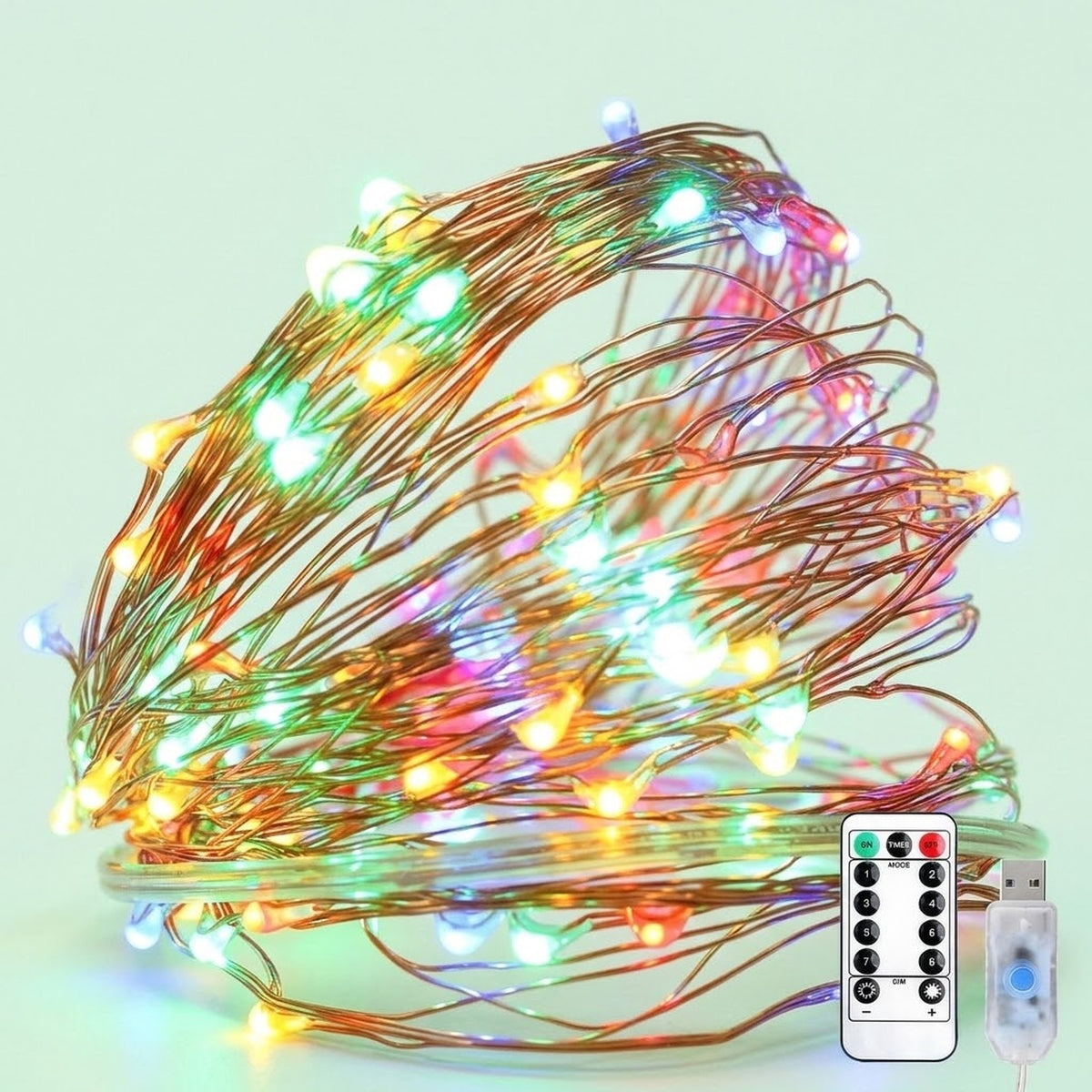 Multicolor LED fairy string lights on a copper wire, shown coiled with a remote control and USB charging cable against a pale mint green background.