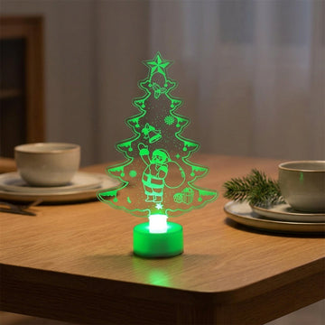 A glowing LED Christmas tree night light shaped like a tree silhouette with a Santa Claus figure, placed on a wooden table in a softly lit dining setting.