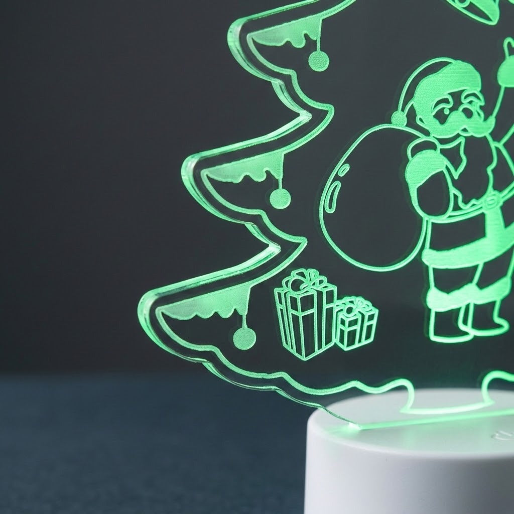 A glowing LED night light shaped like a Christmas tree with Santa Claus and gift boxes, emitting a green light on a white cylindrical base against a dark background.