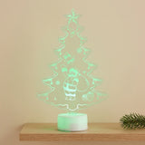 A glowing LED acrylic Christmas tree night light with a Santa Claus design, displayed on a wooden shelf against a beige wall.