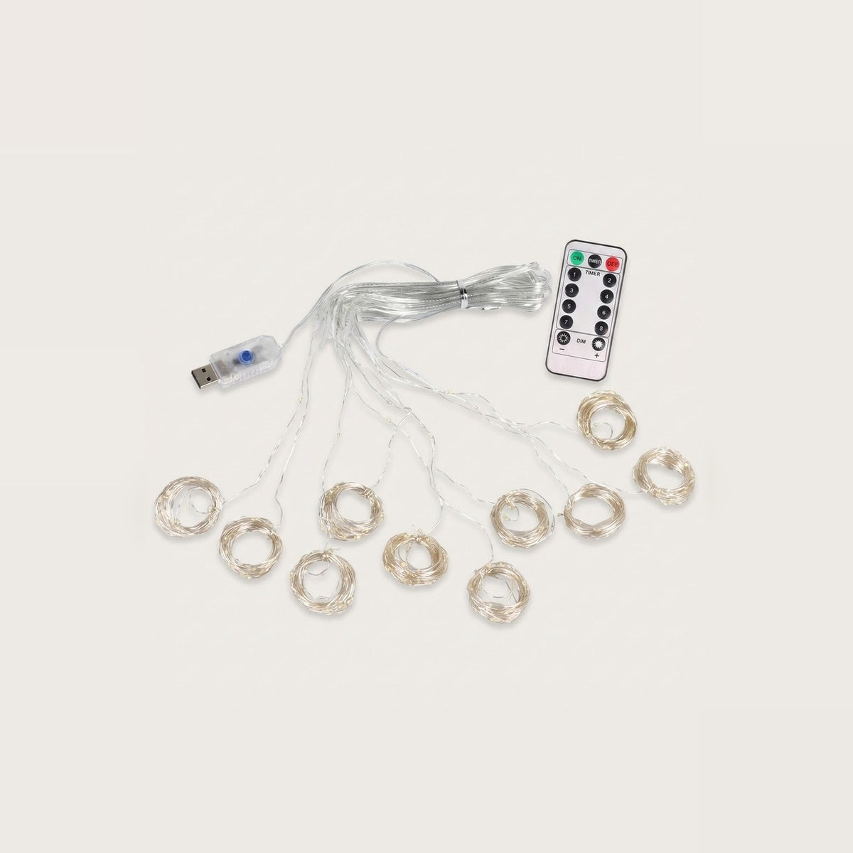 An unlit curtain light with clear wiring fans into circular coils beside a USB connector and white remote on a beige background.