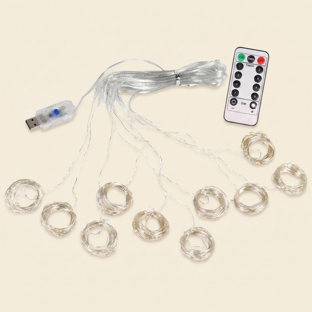 An LED curtain light’s coiled clear strands spread across a cream background beside its connected USB controller and white remote.