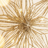 Close-up of a gold glittery star tree topper showing layered frame details and glowing LED wires against a cream background.