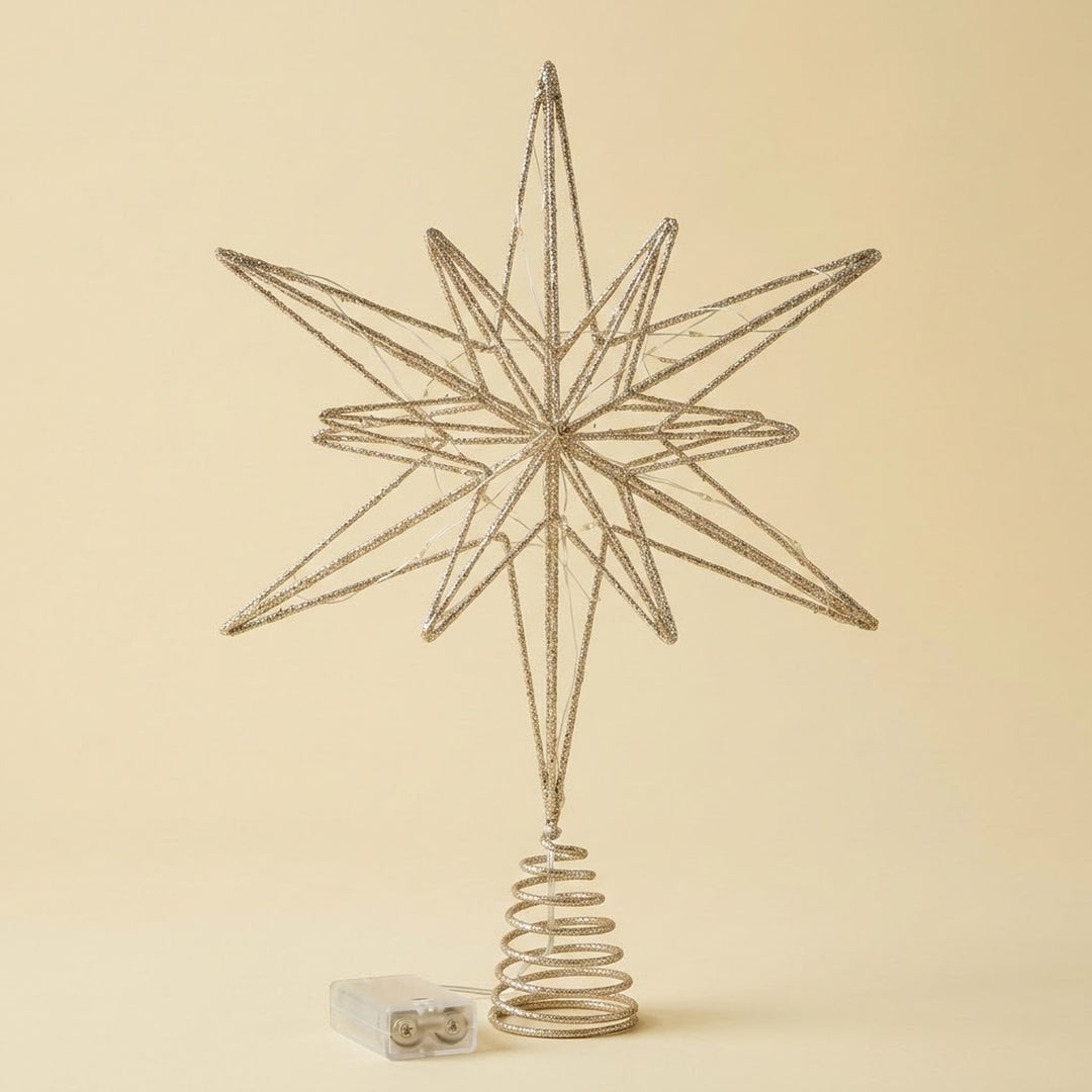 A metallic silver wire star tree topper with a spring base, shown on a solid beige background with a small white box at the bottom.