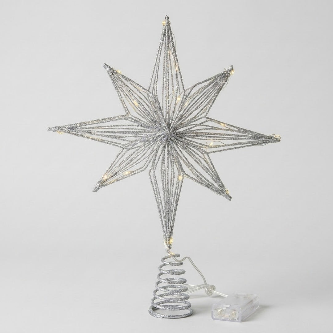 A silver wire star tree topper with warm white LED lights, mounted on a spiral spring base with a small clear plastic battery pack, shown against a light gray background.