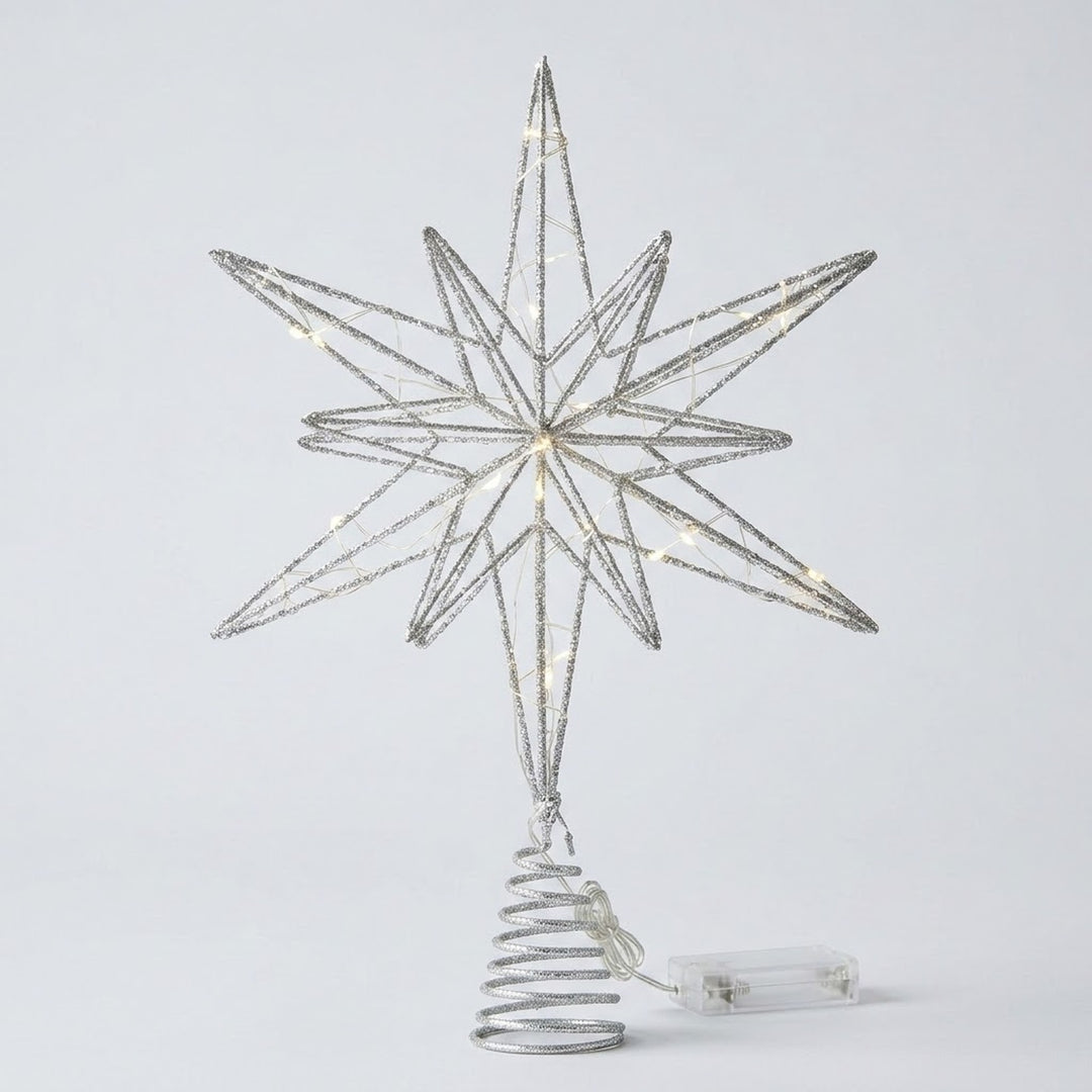 A silver wire star tree topper with warm white string lights, mounted on a spiral tree-shaped base with a clear power cord, shown against a light gray background.