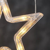 Close-up of a clear star-shaped window light shows warm yellow LEDs inside its transparent frame against a dark gray background.