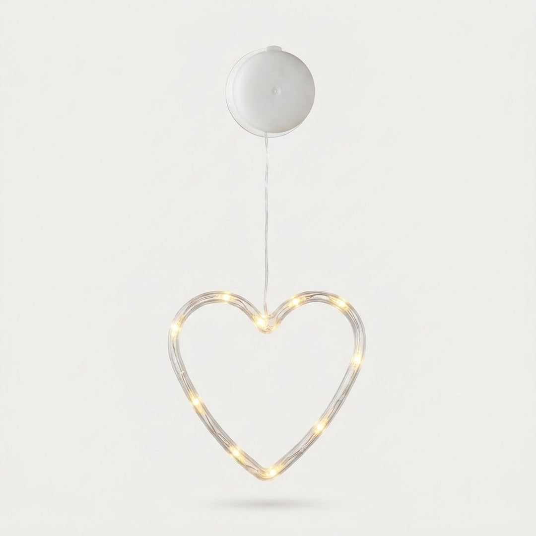 Clear heart-shaped window light glows warm white beneath a round white battery box against a pale background.