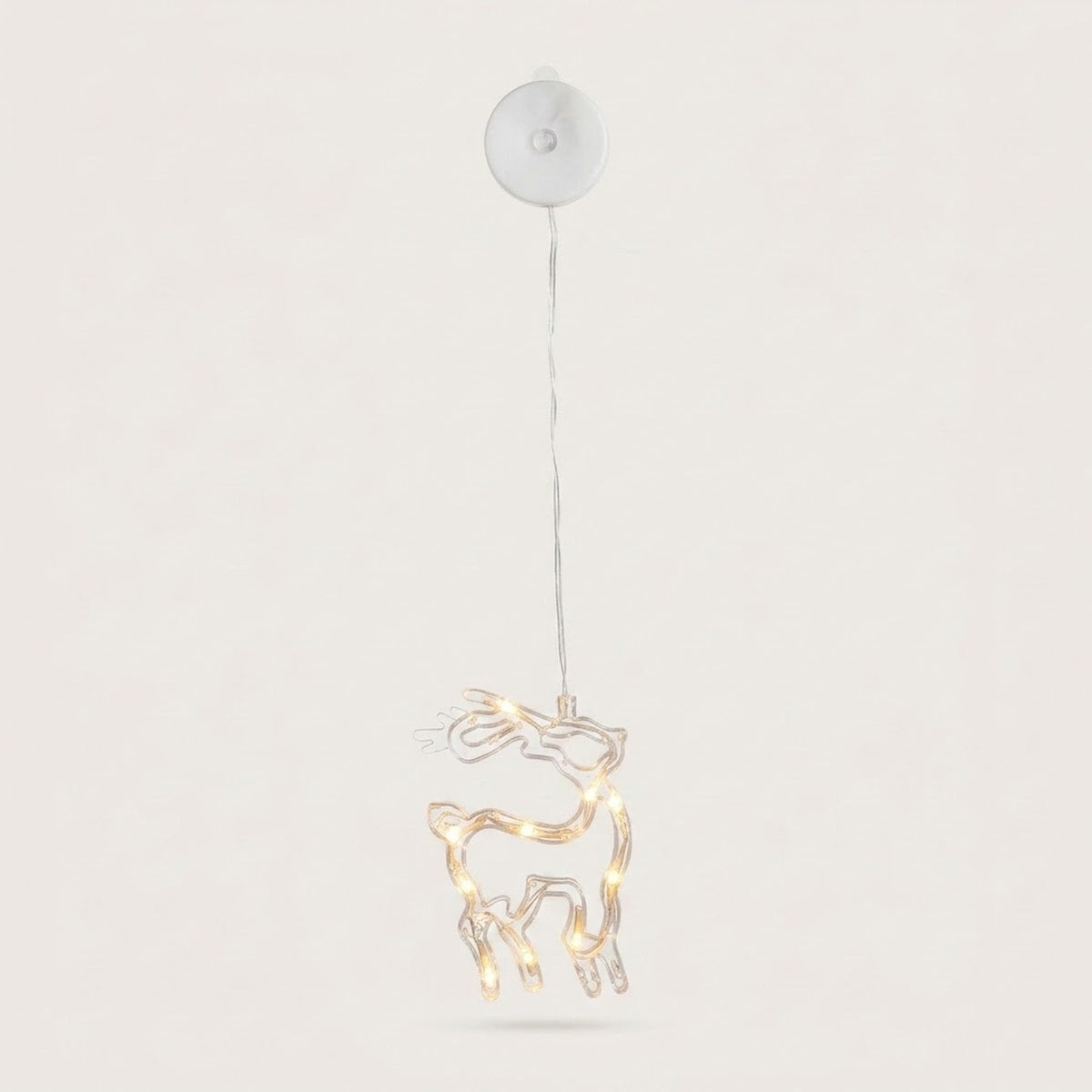 A clear reindeer-shaped window light with warm LEDs hangs beneath a round white housing against an off-white background.