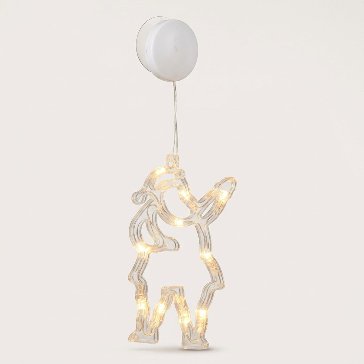 Clear Santa Claus-shaped window light glows warm white beneath a round white battery box and suction cup against a pale background.
