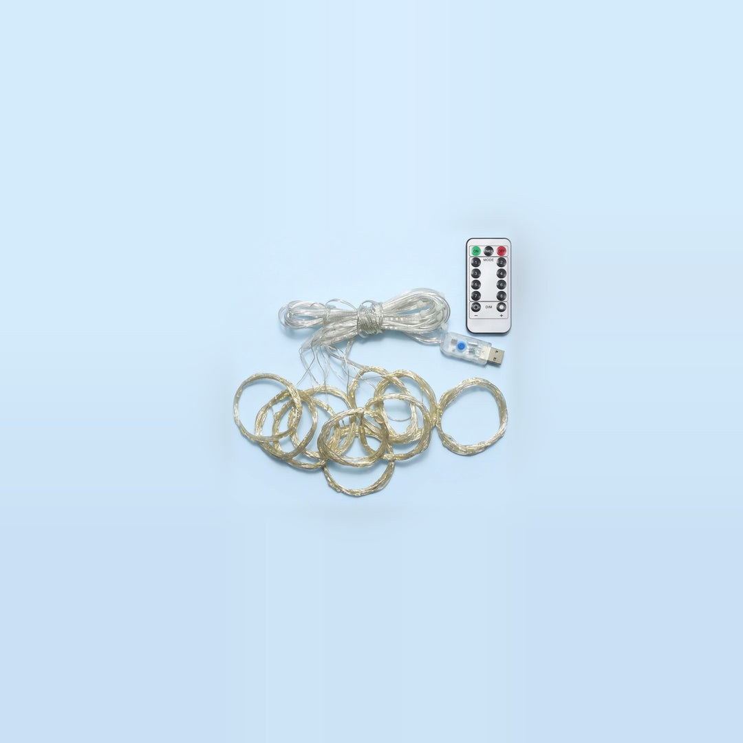 An unlit LED curtain light has coiled clear strands, a USB controller, and a white remote on a pale blue background.