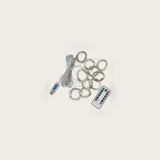 LED curtain light with silver-colored wire loops beside a bundled USB cable and an angled white remote on an off-white background.
