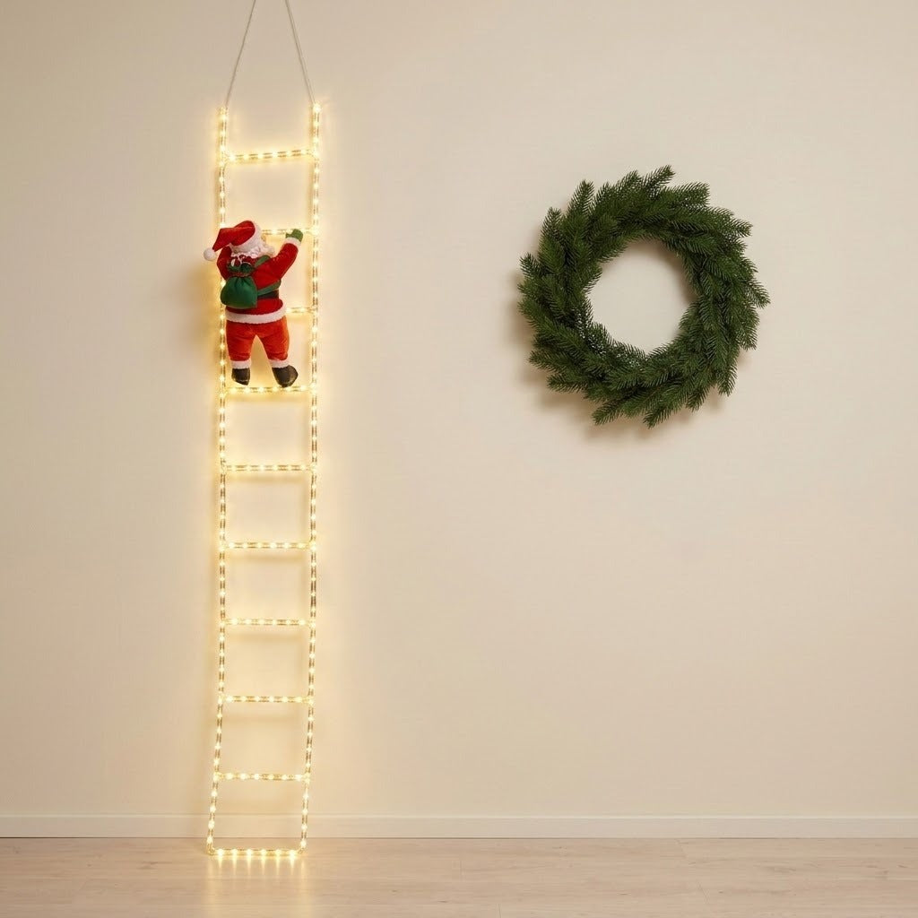 A Christmas-themed scene showing a tall ladder-shaped string light with warm white glow, decorated with a small Santa Claus figure near the top, against a beige wall. A green wreath hangs on the right side of the wall.