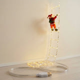 Warm white ladder-shaped Christmas string lights with a Santa ornament hang against a cream wall, with a coiled USB cable below.