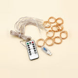 Wireless LED fairy string lights with a USB receiver, a white remote control, and multiple coiled copper wire loops on a light beige background.