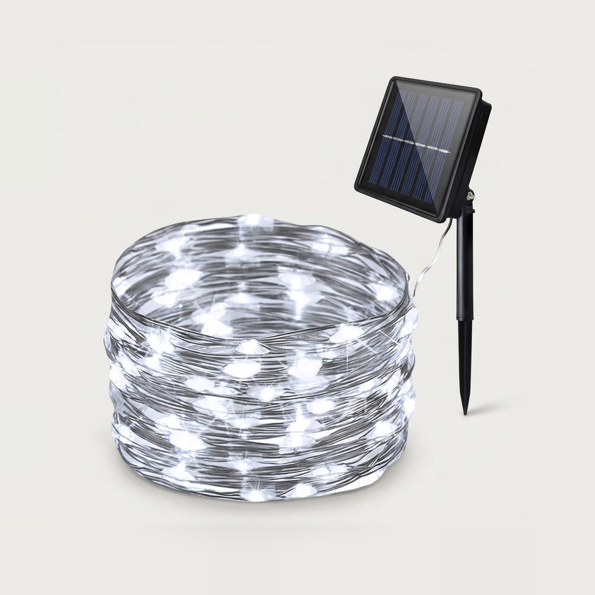 A coil of white solar string lights with a small black solar panel and stake, shown on a plain light beige background.