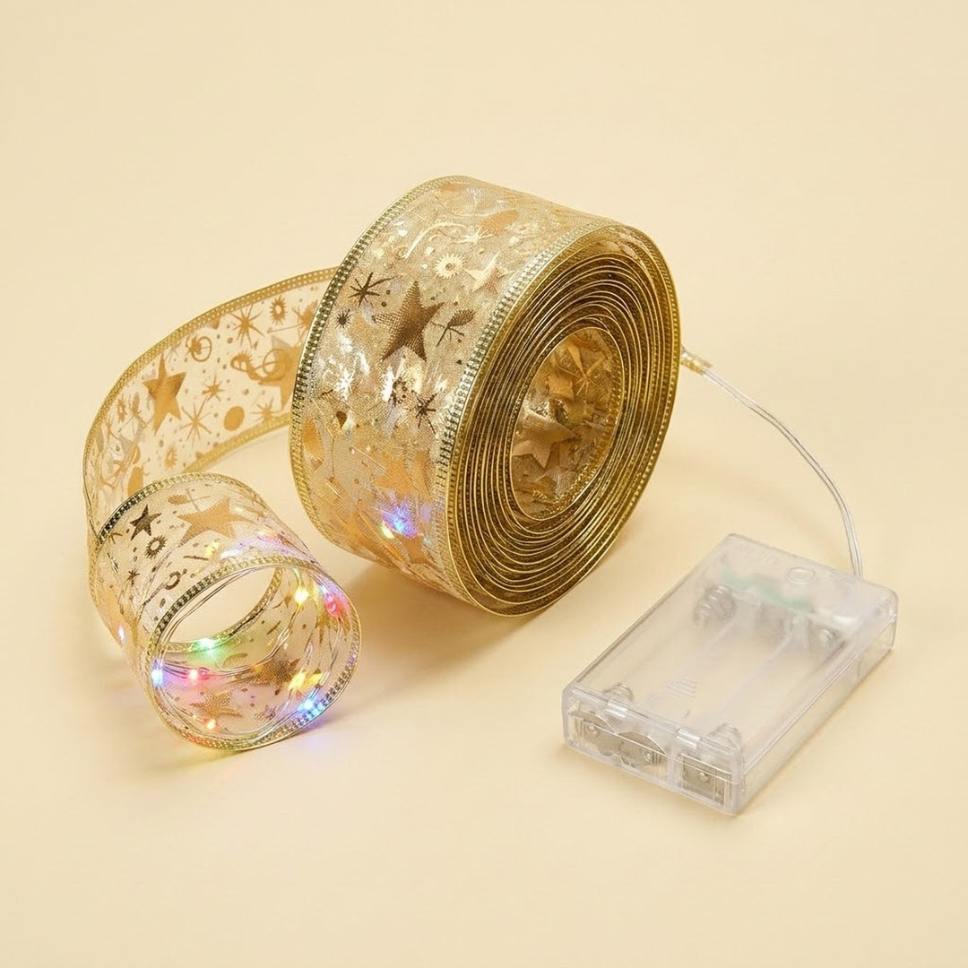 Gold holographic star-patterned ribbon with a clear battery-operated string light control box, shown on a warm beige background.