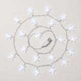 White star-shaped USB string lights arranged in a spiral pattern on a light beige background.