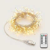 Coiled USB fairy string lights glowing with warm white light, shown with a clear USB connector cable and a white remote control on a light gray background.