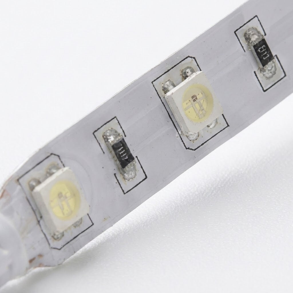 Close-up of a white LED light strip with three visible LED chips and small black surface-mount components on a white background.