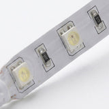 Close-up of a white LED light strip with three visible LED chips and small black surface-mount components on a white background.