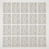 Twenty white wrapping paper sheets with green Christmas trees and festive motifs form four rows of five on a white background.