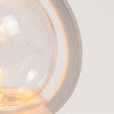 Close-up of the decorative lantern’s transparent ABS shade and curved white plastic housing, illuminated by a warm glow.