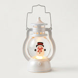 White decorative lantern with wire handle, warm light and snowman design featuring a black hat and red scarf against a pale background.