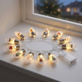 Warm white Christmas string lights with clear, silver-capped bulbs form a circle on a white windowsill beside a translucent battery box.