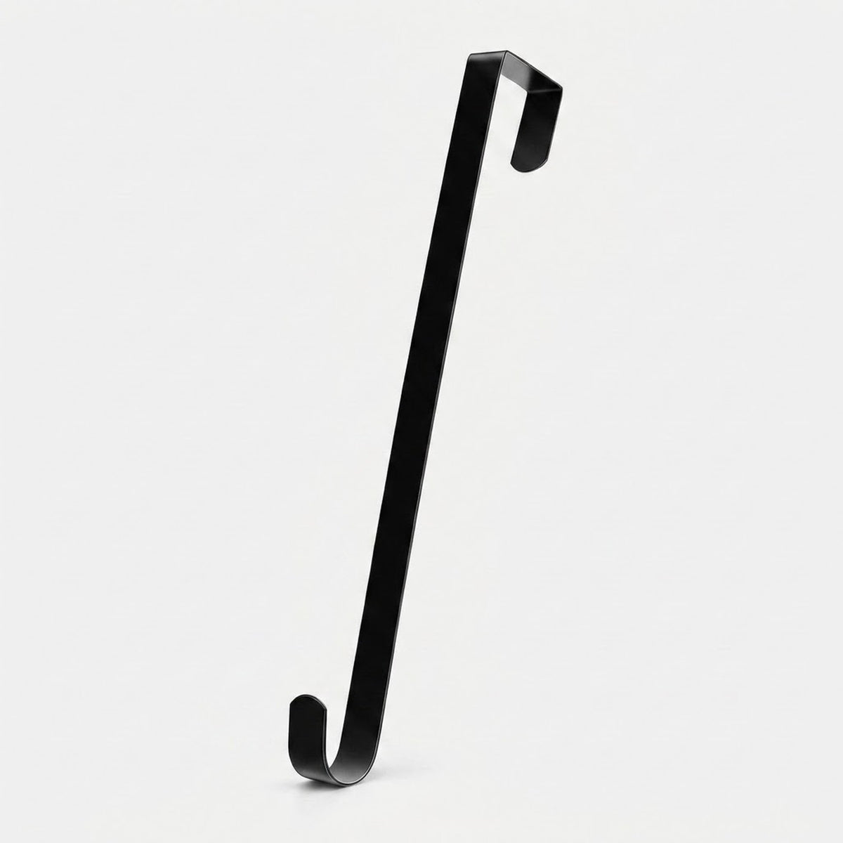 A black zinc alloy wreath hanger stands diagonally against a light background, showing its flat shaft and hooks at both ends.