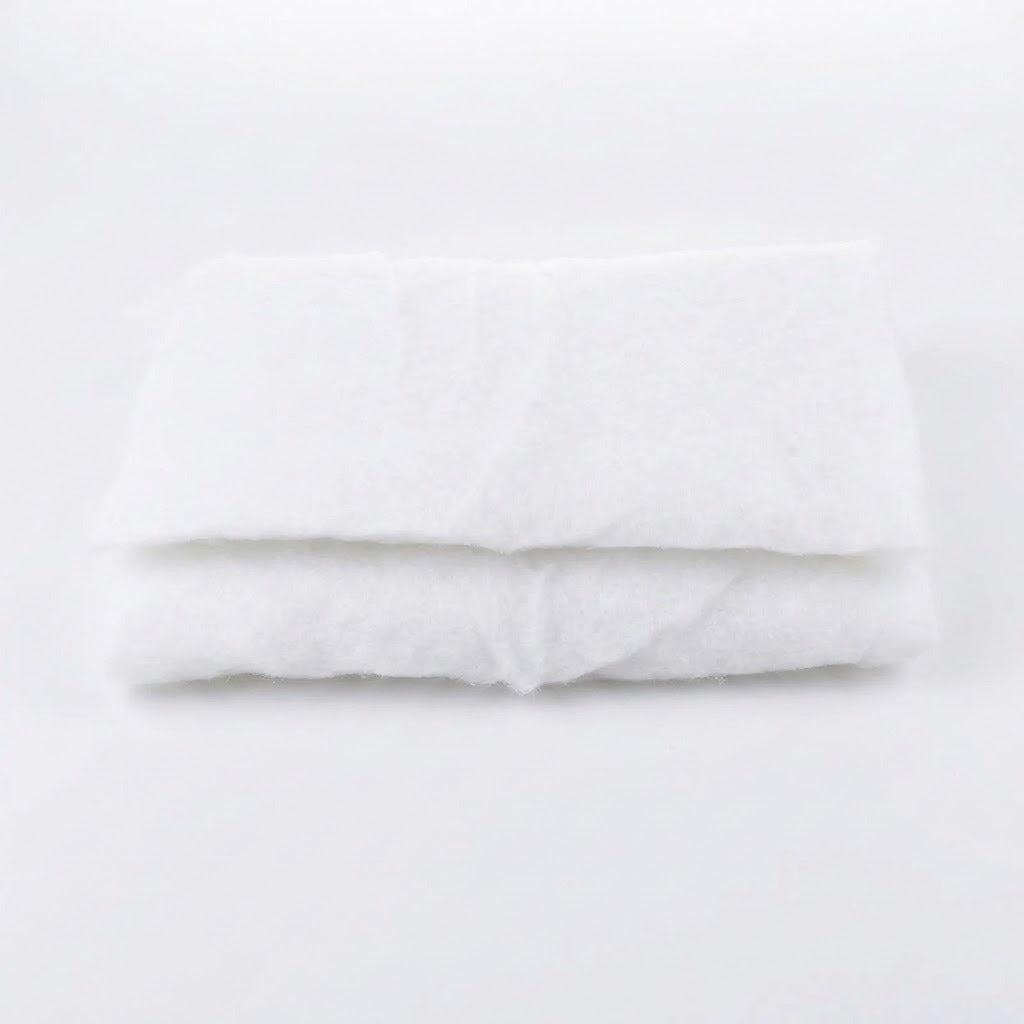 A white snow blanket is folded into stacked rectangular layers against a plain white background.