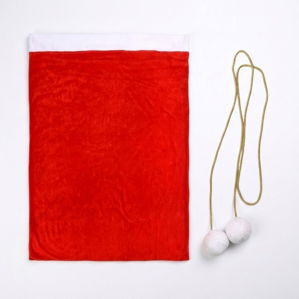 A red fleece gift sack lies flat on white beside a separate gold drawstring with two white pompoms.