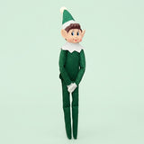 Elf doll with a green fabric outfit, pointed hat, white collar and gloves, and long legs against a pale green background.