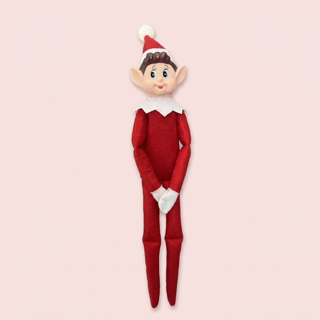 Elf doll with a red fabric outfit, white-trimmed pointed hat, white collar and gloves, and long legs against a pale pink background.