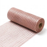 Rose gold mesh decorative ribbon with shiny stripes lies partially unrolled from a cardboard core against a white background.