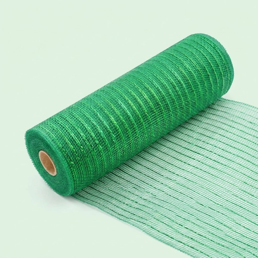 Green mesh decorative ribbon lies partially unrolled diagonally on a pale green background, with its loose end extending toward the lower right.