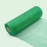 Green mesh decorative ribbon lies partially unrolled diagonally on a pale green background, with its loose end extending toward the lower right.
