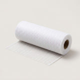 White iridescent mesh decorative ribbon lies partially unrolled on a cream background, with its brown cardboard core visible.