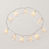 Clear reindeer and Christmas tree string lights glow warm white in a loose circle on a white background.