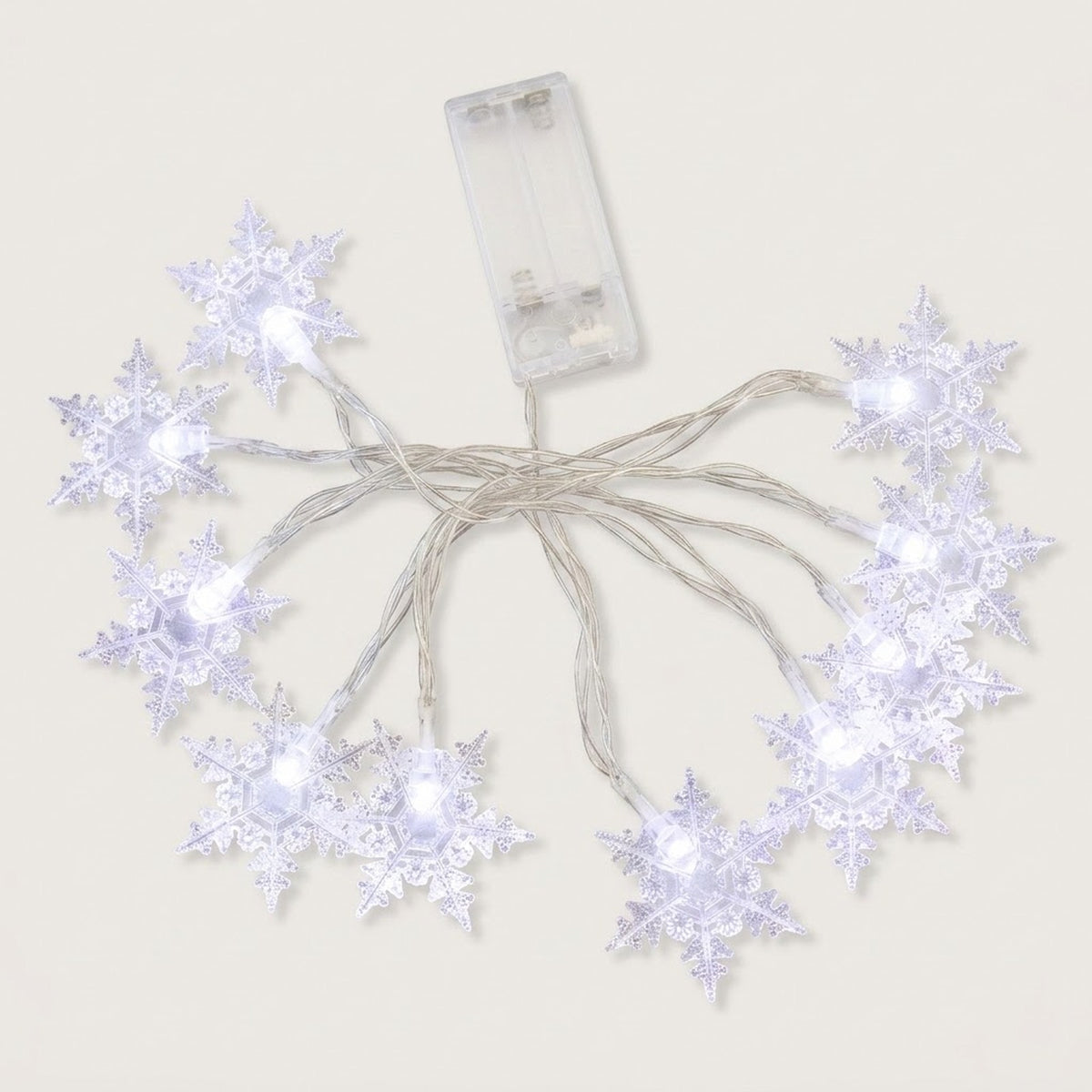 Clear snowflake string lights glow cool white, with silver-colored wires and a transparent battery box on a white background.