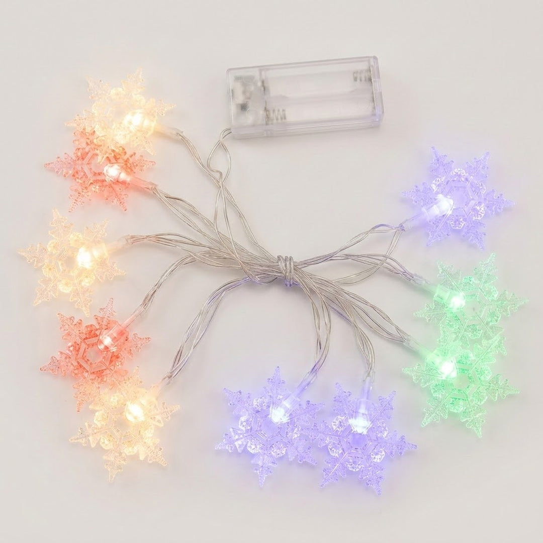Clear snowflake string lights glow yellow, red, purple, and green beside a transparent battery box on a white background.