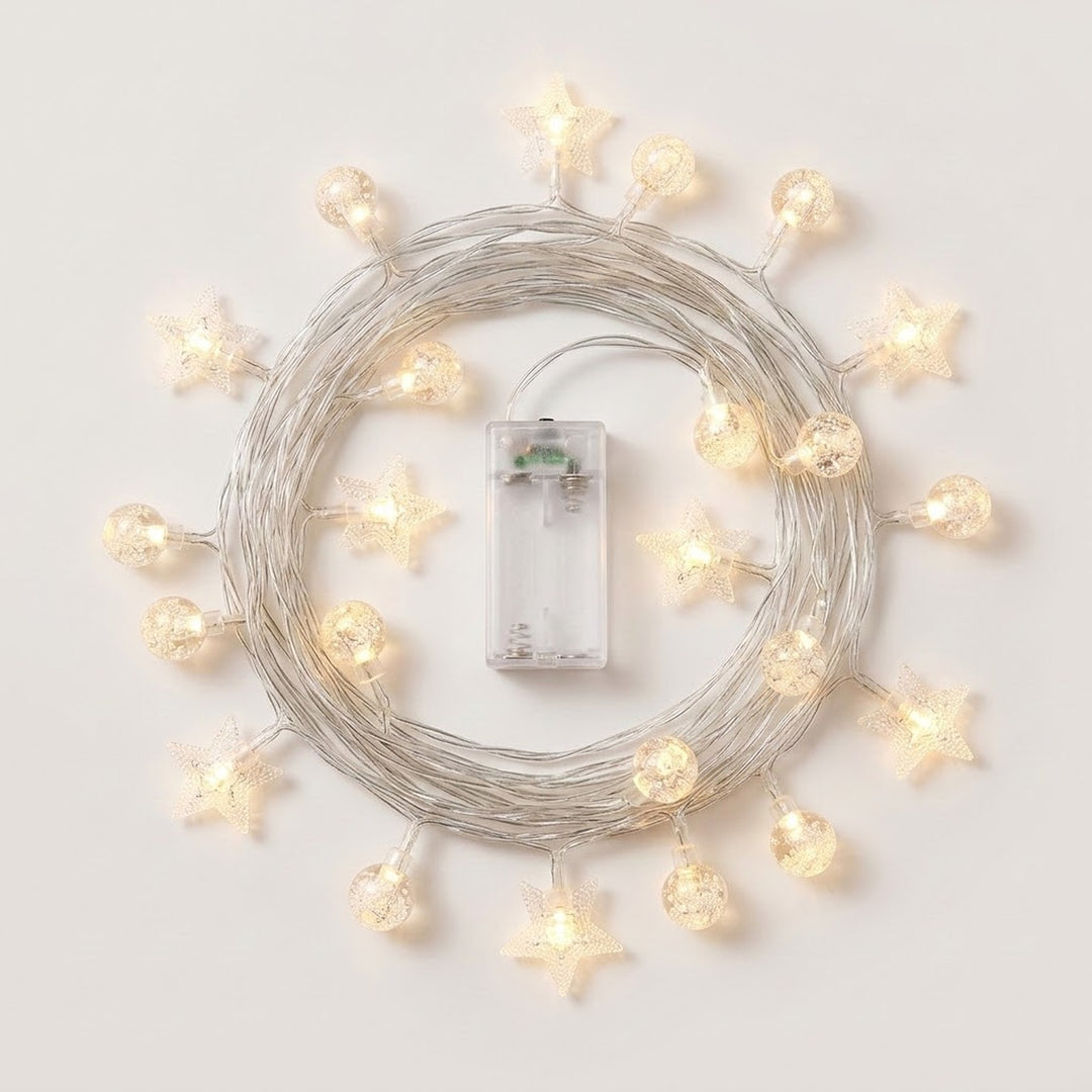 Warm white star and globe string lights surround coiled silver-colored wire and a transparent battery box on a white background.