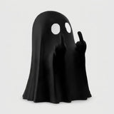 A black ghost-shaped figurine or lamp with two white circular eye cutouts and raised hands showing middle fingers, photographed on a plain light gray background.