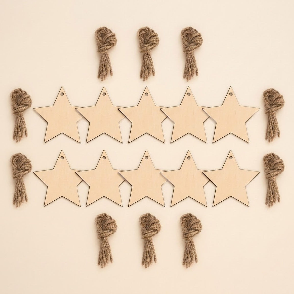 Ten unfinished wood star ornament blanks with hanging holes sit in two rows, surrounded by brown twine bundles on a cream background.