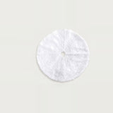 Round white fluffy Christmas tree skirt with a central hole and slit, displayed flat against a light neutral background.